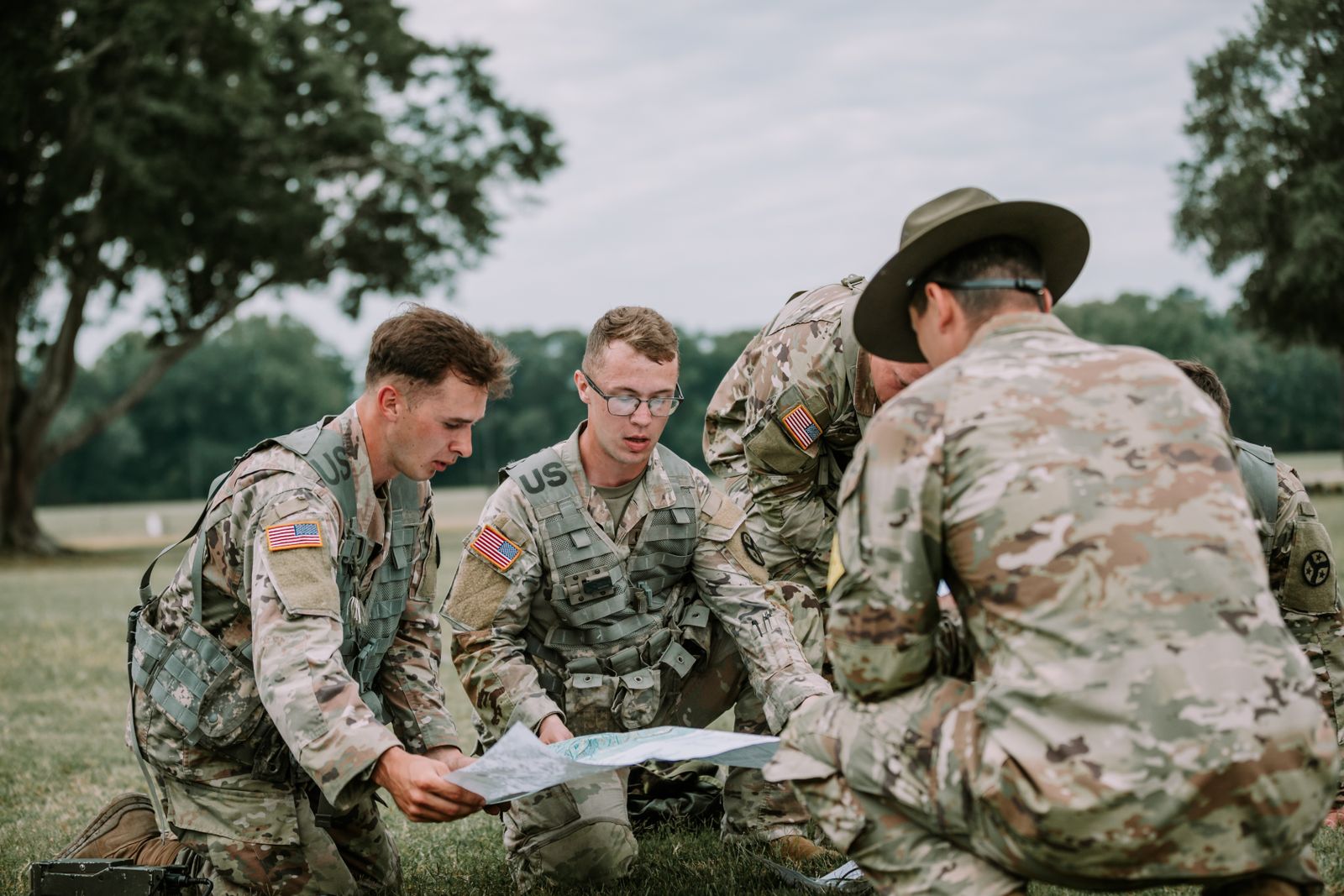 Three people studying route maps spread out on a table