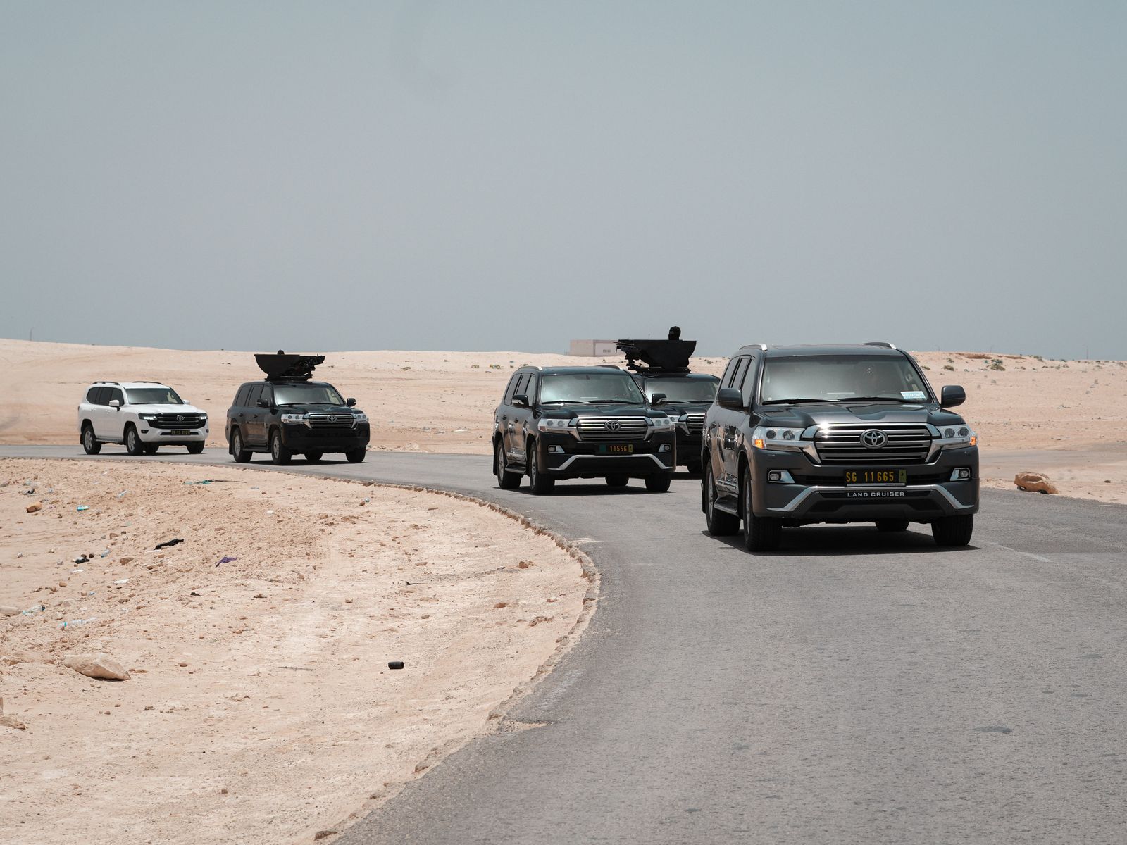 Armoured vehicles moving along a desert road