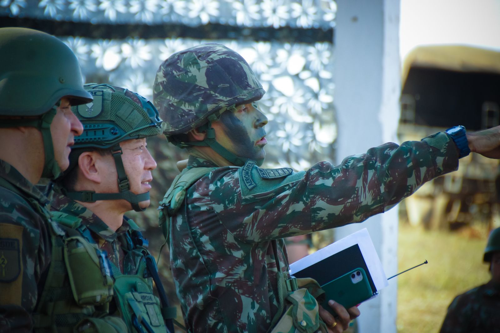 Personnel in helmets conferring during an outdoor exercise